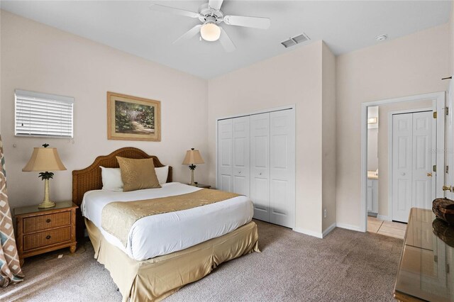 bedroom with ceiling fan, light colored carpet, and a closet