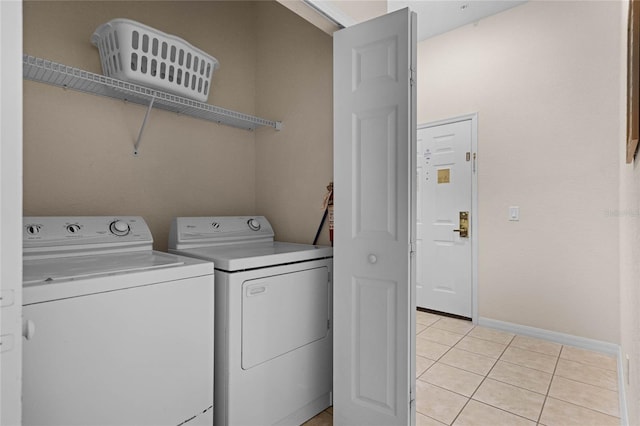 laundry area with washer and dryer and light tile patterned floors