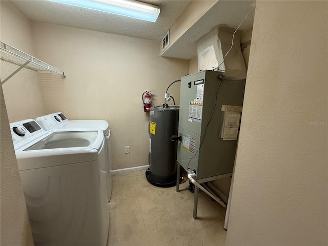 laundry room featuring washer and clothes dryer, electric water heater, and heating unit