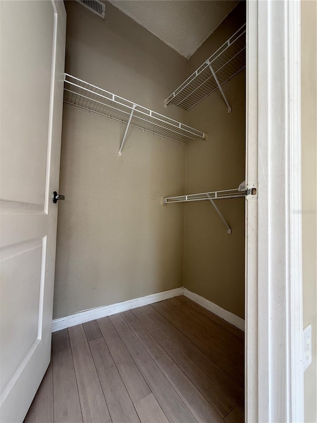 spacious closet featuring hardwood / wood-style flooring