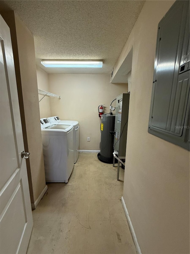 laundry area with a textured ceiling, washing machine and dryer, water heater, and electric panel