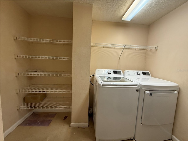 washroom with separate washer and dryer and a textured ceiling