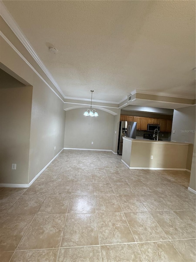 unfurnished living room with a textured ceiling, vaulted ceiling, light tile patterned flooring, ornamental molding, and a chandelier