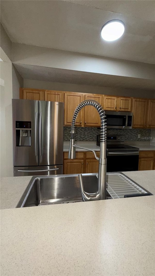 kitchen with stainless steel appliances, tasteful backsplash, and sink