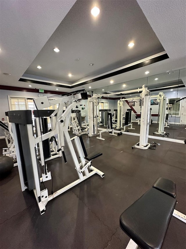 exercise room featuring a textured ceiling and a tray ceiling