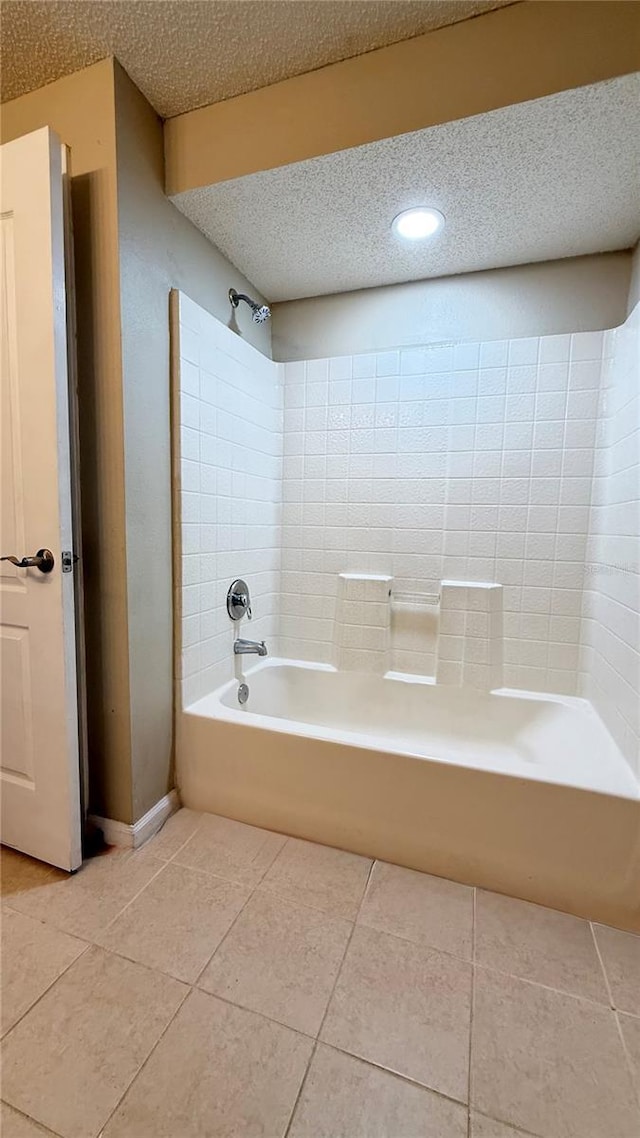 bathroom with a textured ceiling,  shower combination, and tile patterned floors