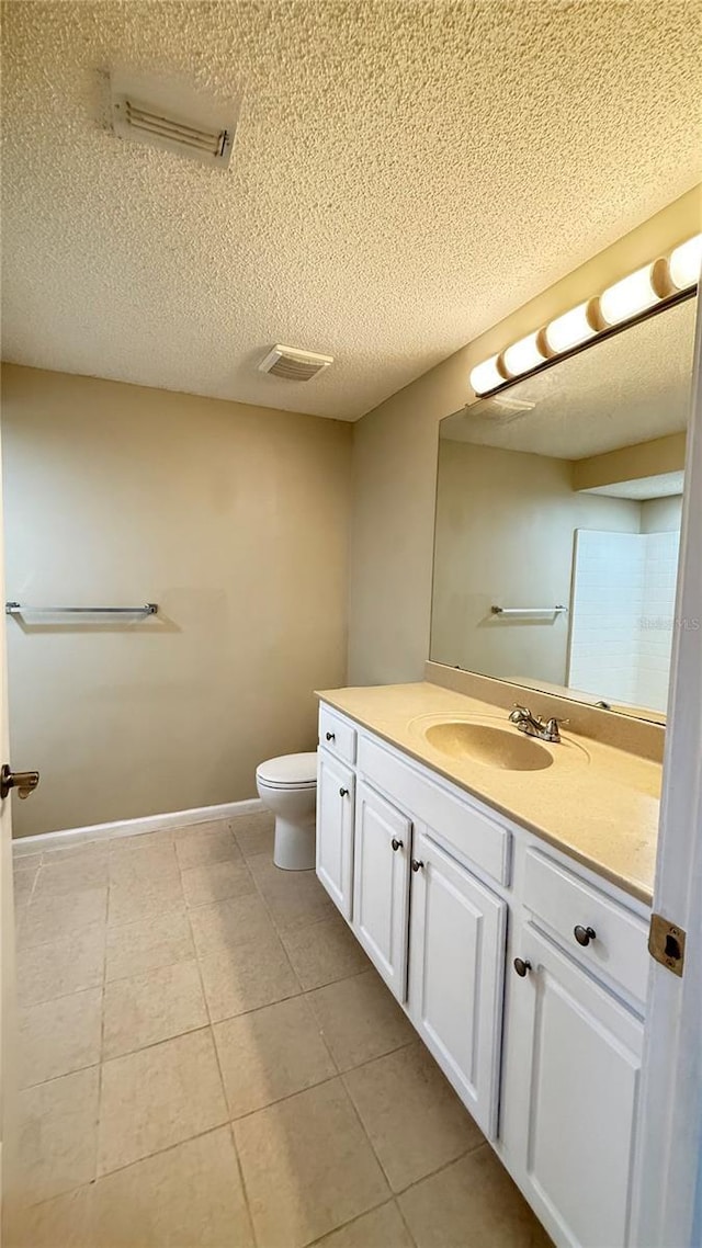 bathroom featuring a textured ceiling, tile patterned floors, vanity, and toilet