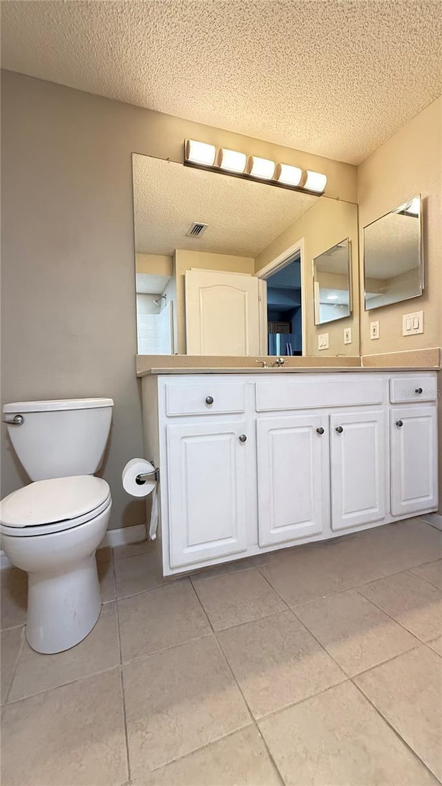 bathroom featuring tile patterned flooring, a textured ceiling, and vanity