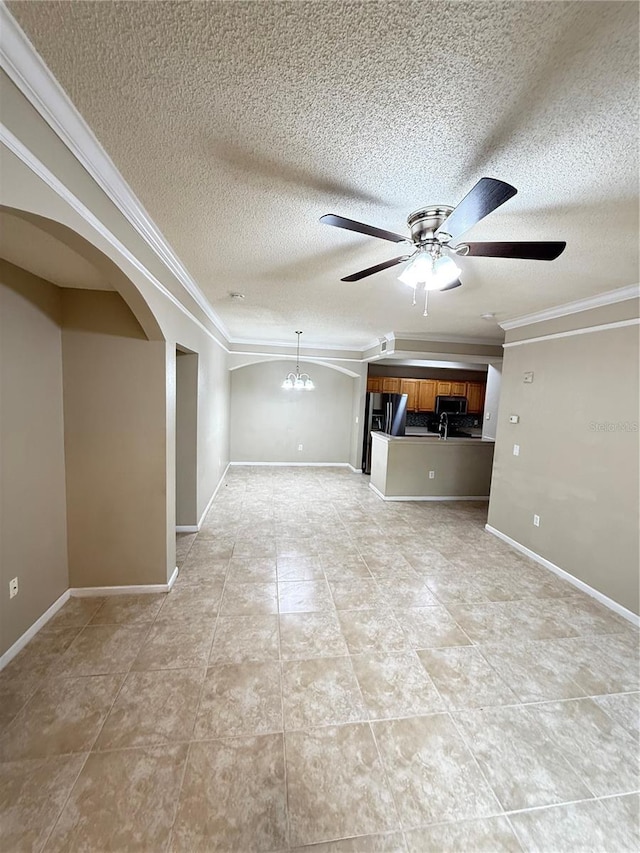 unfurnished living room featuring ceiling fan with notable chandelier, a textured ceiling, and ornamental molding