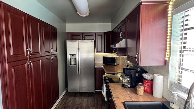 kitchen with dark hardwood / wood-style flooring, a healthy amount of sunlight, stainless steel fridge, and backsplash