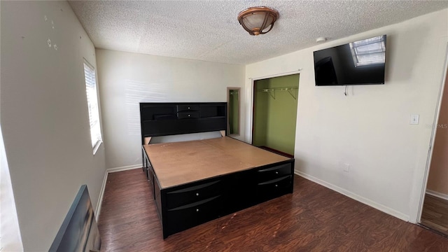 bedroom featuring dark hardwood / wood-style floors, a closet, and a textured ceiling