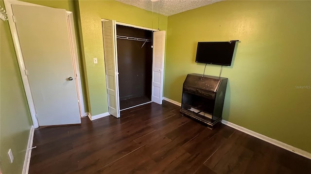 unfurnished bedroom with dark hardwood / wood-style flooring, a closet, and a textured ceiling