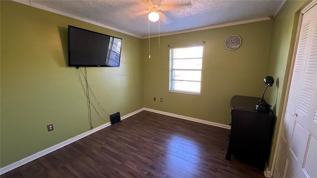 unfurnished bedroom with ceiling fan, a textured ceiling, wood finished floors, baseboards, and ornamental molding