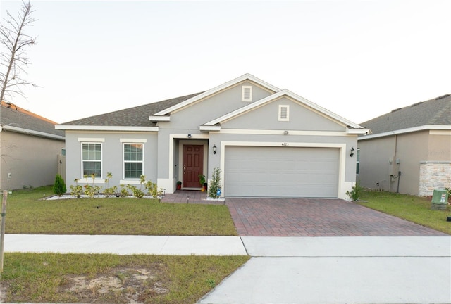 single story home featuring central AC unit, a front yard, and a garage