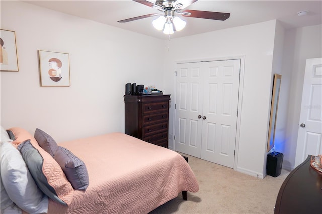 carpeted bedroom featuring ceiling fan and a closet