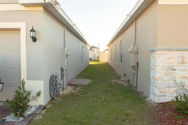 view of home's exterior with a garage and a yard