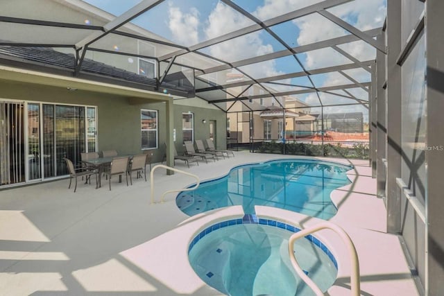 view of pool featuring a patio, an in ground hot tub, and glass enclosure