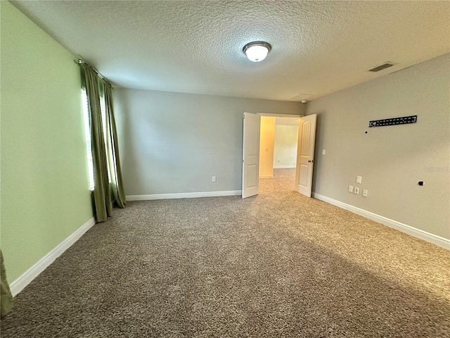 spare room featuring a textured ceiling and carpet flooring