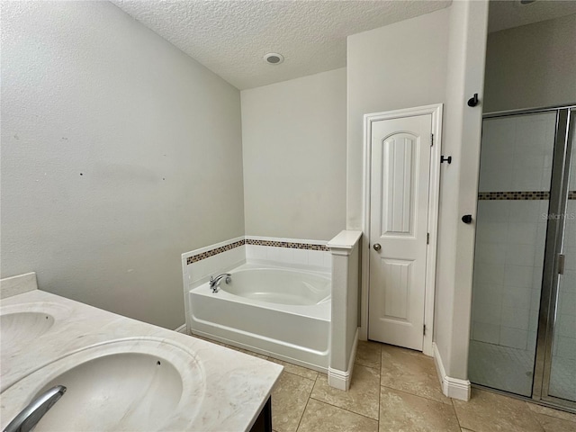 bathroom featuring vanity, independent shower and bath, tile patterned floors, and a textured ceiling