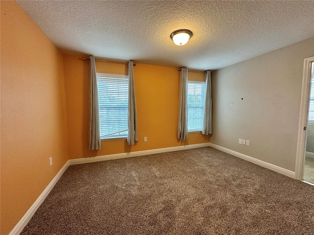 carpeted empty room with a textured ceiling