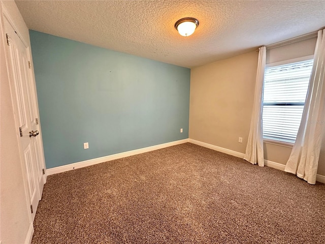 carpeted empty room with a textured ceiling