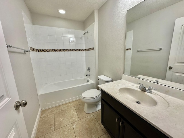 full bathroom with tiled shower / bath combo, toilet, a textured ceiling, and vanity