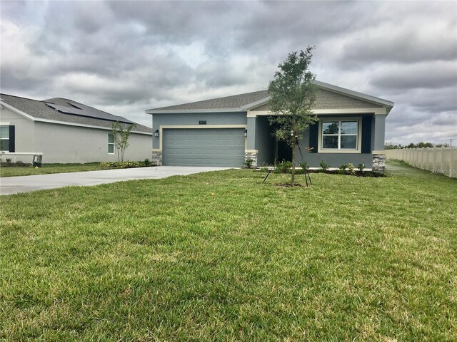 single story home featuring a garage and a front lawn