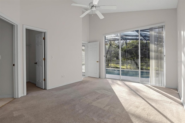 interior space featuring ceiling fan, high vaulted ceiling, and light colored carpet