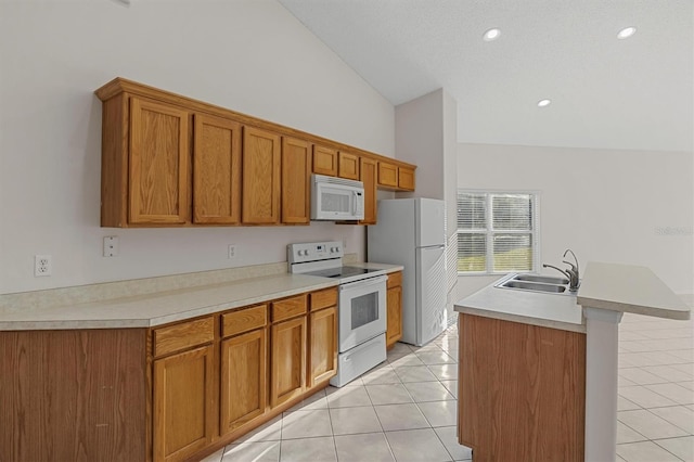 kitchen with lofted ceiling, white appliances, a kitchen island with sink, sink, and light tile patterned flooring