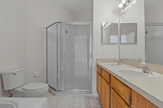 bathroom with tile patterned floors, vanity, toilet, and an enclosed shower