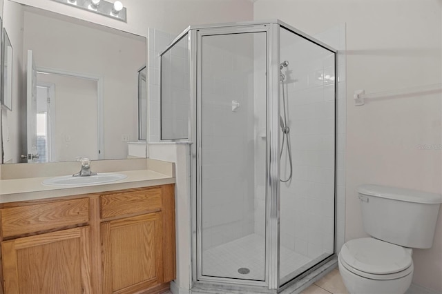 bathroom with tile patterned flooring, vanity, a shower with shower door, and toilet