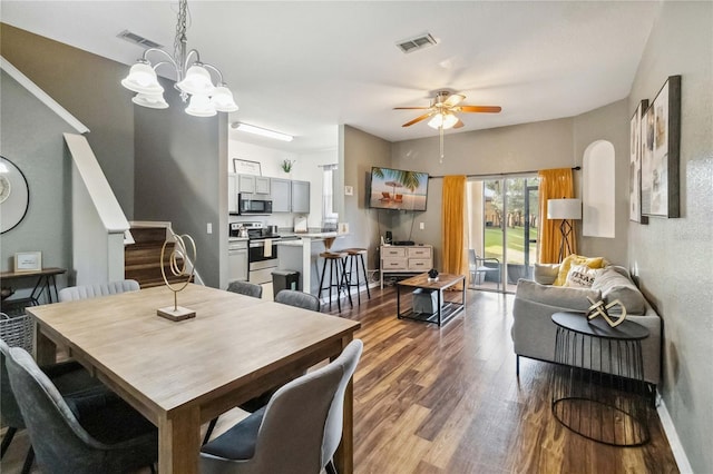 dining room with ceiling fan with notable chandelier and hardwood / wood-style flooring