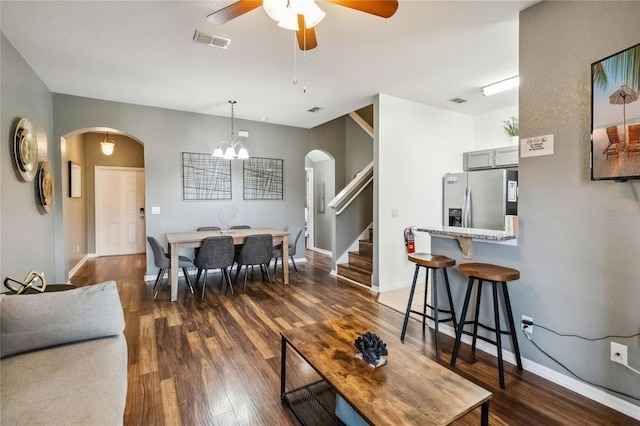 living room featuring ceiling fan with notable chandelier and dark hardwood / wood-style floors