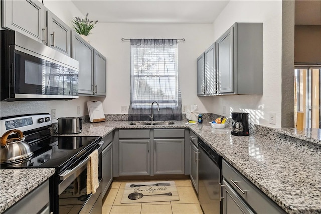 kitchen featuring gray cabinets, sink, stainless steel appliances, and light tile patterned flooring