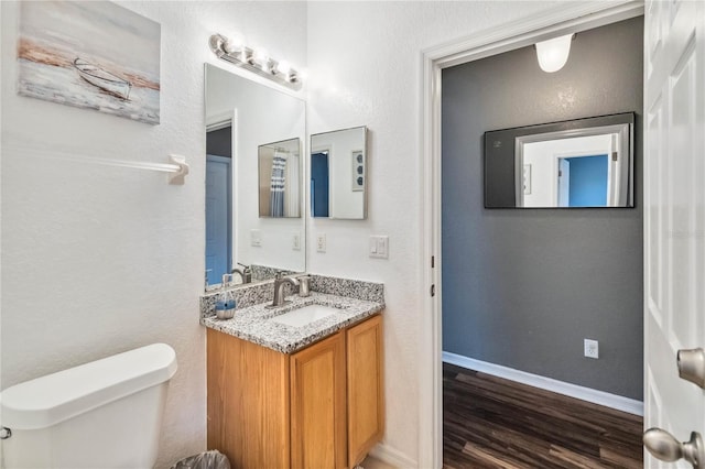 bathroom featuring hardwood / wood-style flooring, vanity, and toilet