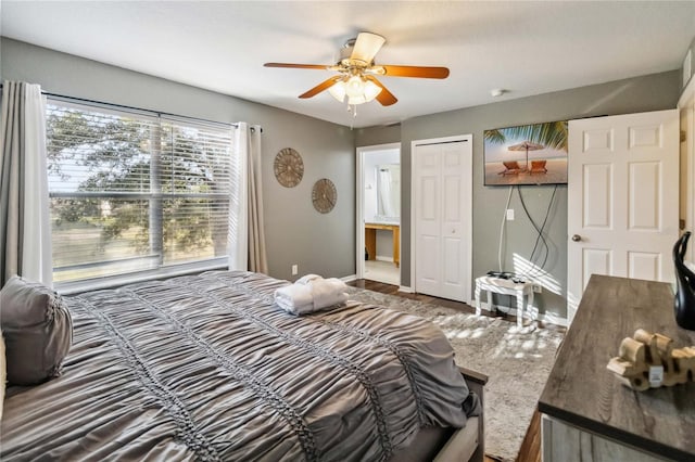 bedroom with a closet, ensuite bath, and ceiling fan