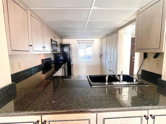 kitchen with sink, black appliances, and a drop ceiling