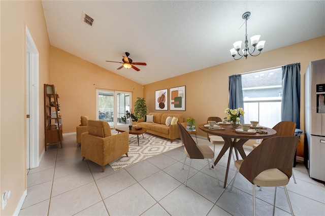 tiled living room with ceiling fan with notable chandelier and lofted ceiling