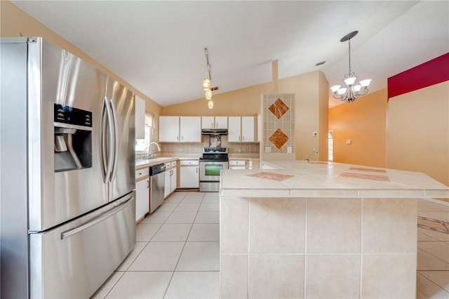 kitchen featuring vaulted ceiling, light tile patterned flooring, decorative light fixtures, stainless steel appliances, and white cabinets