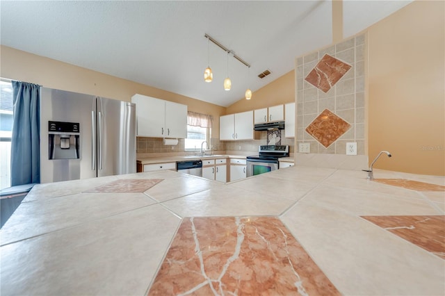 kitchen featuring appliances with stainless steel finishes, sink, white cabinetry, pendant lighting, and decorative backsplash