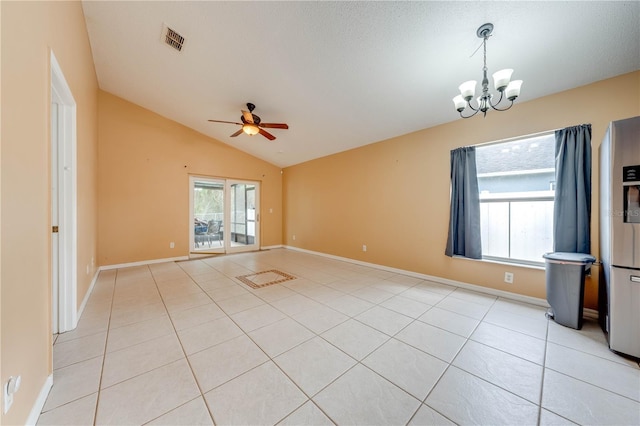 tiled empty room featuring ceiling fan with notable chandelier, a textured ceiling, and lofted ceiling