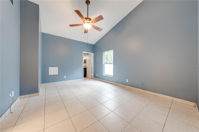 empty room featuring high vaulted ceiling, ceiling fan, and light tile patterned floors