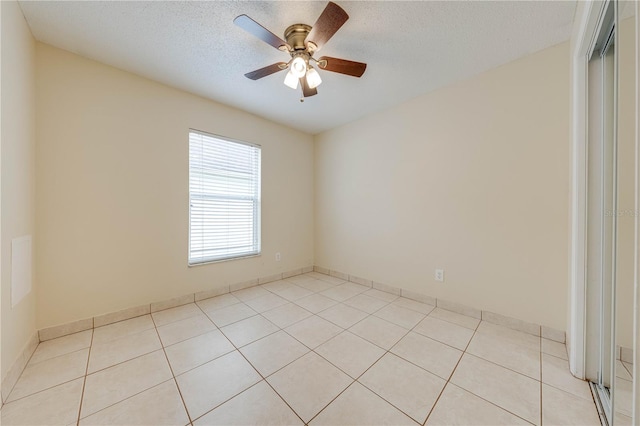 tiled spare room featuring ceiling fan and a textured ceiling