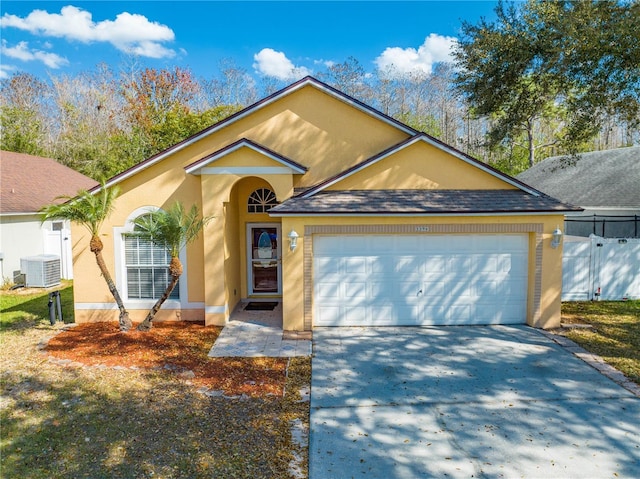 view of front of property with a garage and cooling unit