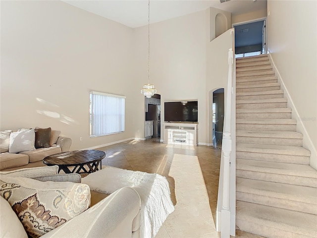 living room with tile patterned flooring, a high ceiling, and a notable chandelier