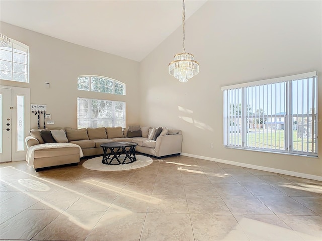 tiled living room with high vaulted ceiling, a healthy amount of sunlight, and a notable chandelier