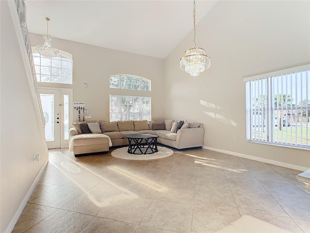 tiled living room with high vaulted ceiling, plenty of natural light, and a notable chandelier