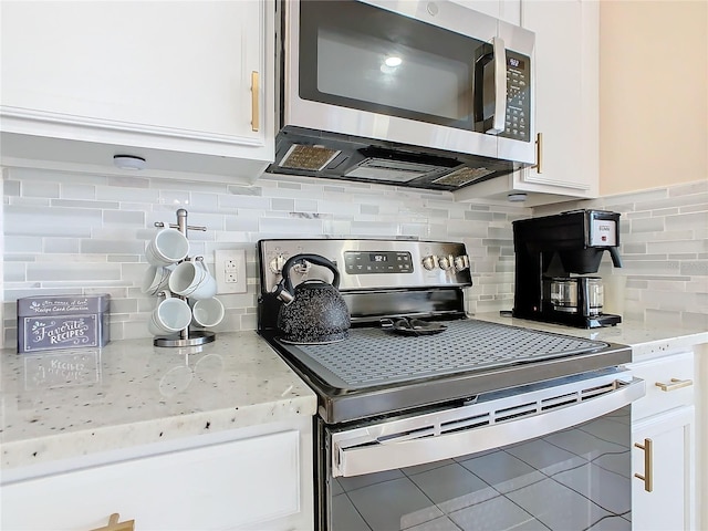 kitchen featuring appliances with stainless steel finishes, tasteful backsplash, and white cabinetry