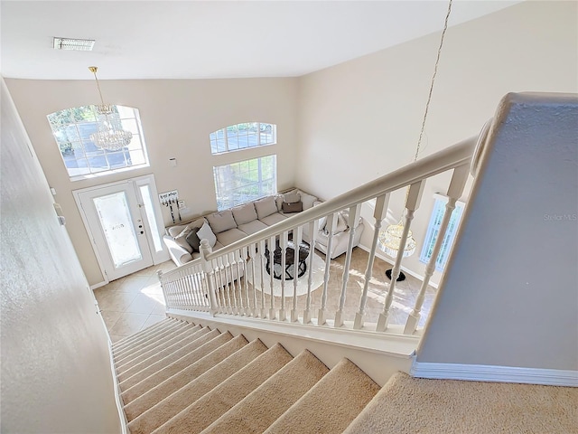 staircase with tile patterned flooring and a notable chandelier