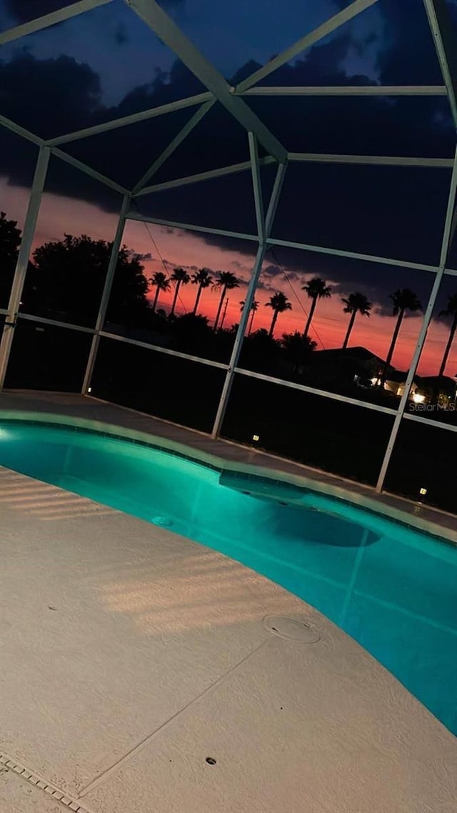 pool at dusk with glass enclosure